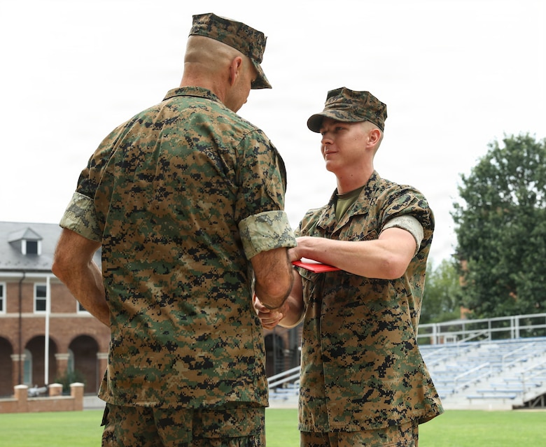 U.S. Marine Corps Lance Cpl. Logan Carpenter, a rifleman with Guard Company, Marine Barracks Washington, shakes hands with Col. Jason Copeland, commanding officer of Marine Barracks Washington, left, after receiving the Navy and Marine Corps Achievement Medal during an award ceremony at Marine Barracks Washington D.C., Sept. 3, 2026. Carpenter was awarded for his decisive actions as part of a reaction team that safely neutralized an armed threat on the installation. (U.S. Marine Corps photo by Cpl. Brynn L. Bouchard)