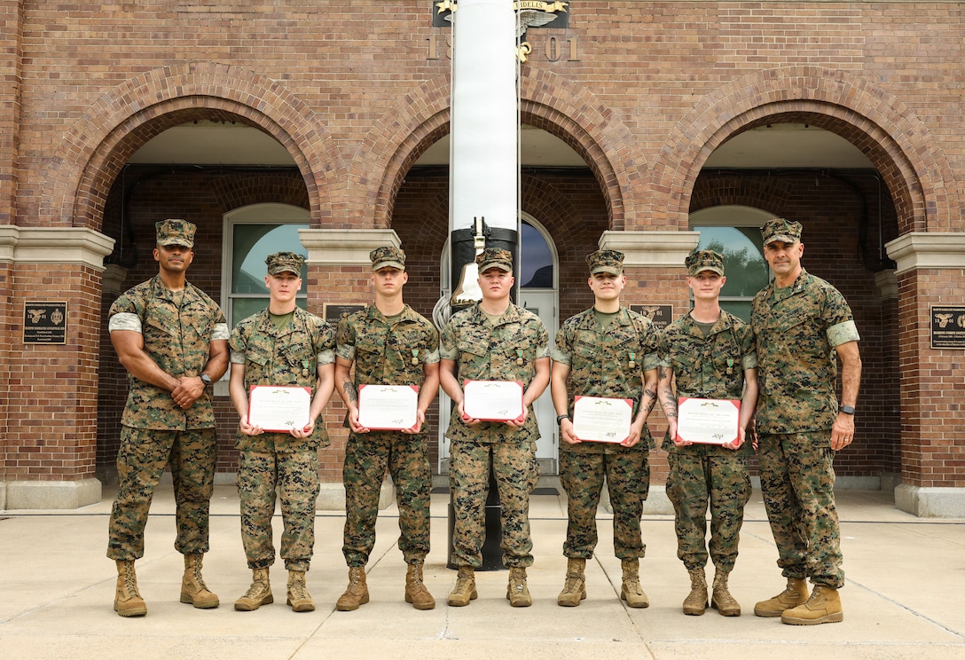 U.S. Marines with Guard Company, Marine Barracks Washington pose for a photo with Sgt. Maj. Juan P. Segura, sergeant major, Marine Barracks Washington, left, and Col. Jason Copeland, commanding officer of Marine Barracks Washington, right, after an award ceremony at Marine Barracks Washington, D.C., Sept. 3, 2026. The Marines were awarded for their decisive actions as part of a reaction team that safely neutralized an armed threat on the installation. (U.S. Marine Corps photo by Cpl. Brynn L. Bouchard)