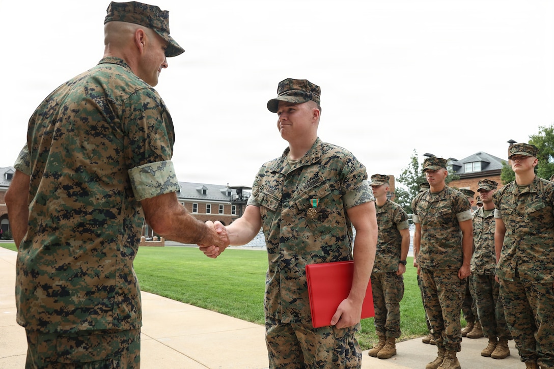 U.S. Marine Corps Cpl. Ian L. Caudy, a rifleman with Guard Company, Marine Barracks Washington, shakes hands with Col. Jason Copeland, commanding officer of Marine Barracks Washington, left, after receiving the Navy and Marine Corps Achievement Medal during an award ceremony at Marine Barracks Washington D.C., Sept. 3, 2026. Caudy was awarded for his decisive actions as part of a reaction team that safely neutralized an armed threat on the installation. (U.S. Marine Corps photo by Cpl. Brynn L. Bouchard)