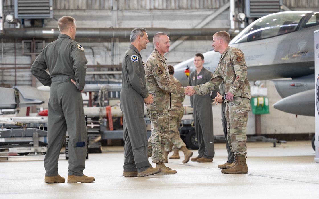 Air Force Chief of Staff Gen. Ken Wilsbach, center left, and Chief Master Sergeant of the Air Force David Wolfe, center right, greet Airmen during a fighter deployment brief.