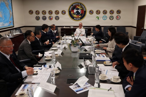 Rear Adm. Kevin Brown, center, commander of Naval Medical Forces Pacific and director of Defense Health Network-Pacific Rim, welcomes a senior Japanese healthcare delegation to the NMFP headquarters, Aug. 25, 2026. The bilateral visit focused on advancing interoperability, shipboard clinical training, and hospital ship modernization across the Pacific theater. (U.S. Navy photo by Arsenio R. Cortez Jr.)