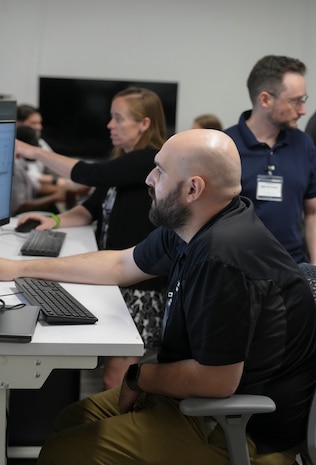 men and women siting work on computers