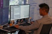 a man wearing a headset works on a computer