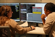 two women look at two computer screens
