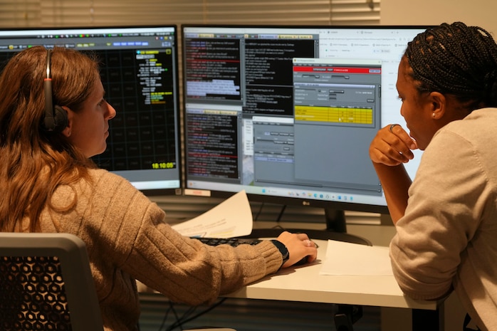 two women look at two computer screens