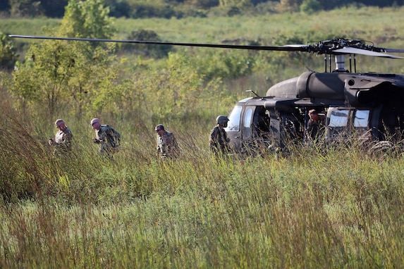 On Day 1 of the spur ride, Soldiers disembark from a UH-60 helicopter piloted by the Georgia National Guard and head for the nearby wood line.