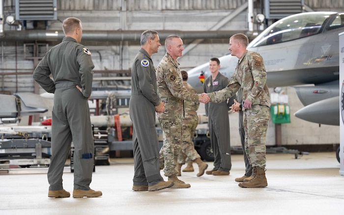 Air Force Chief of Staff Gen. Ken Wilsbach, center left, and Chief Master Sergeant of the Air Force David Wolfe, center right, greet Airmen during a fighter deployment brief.