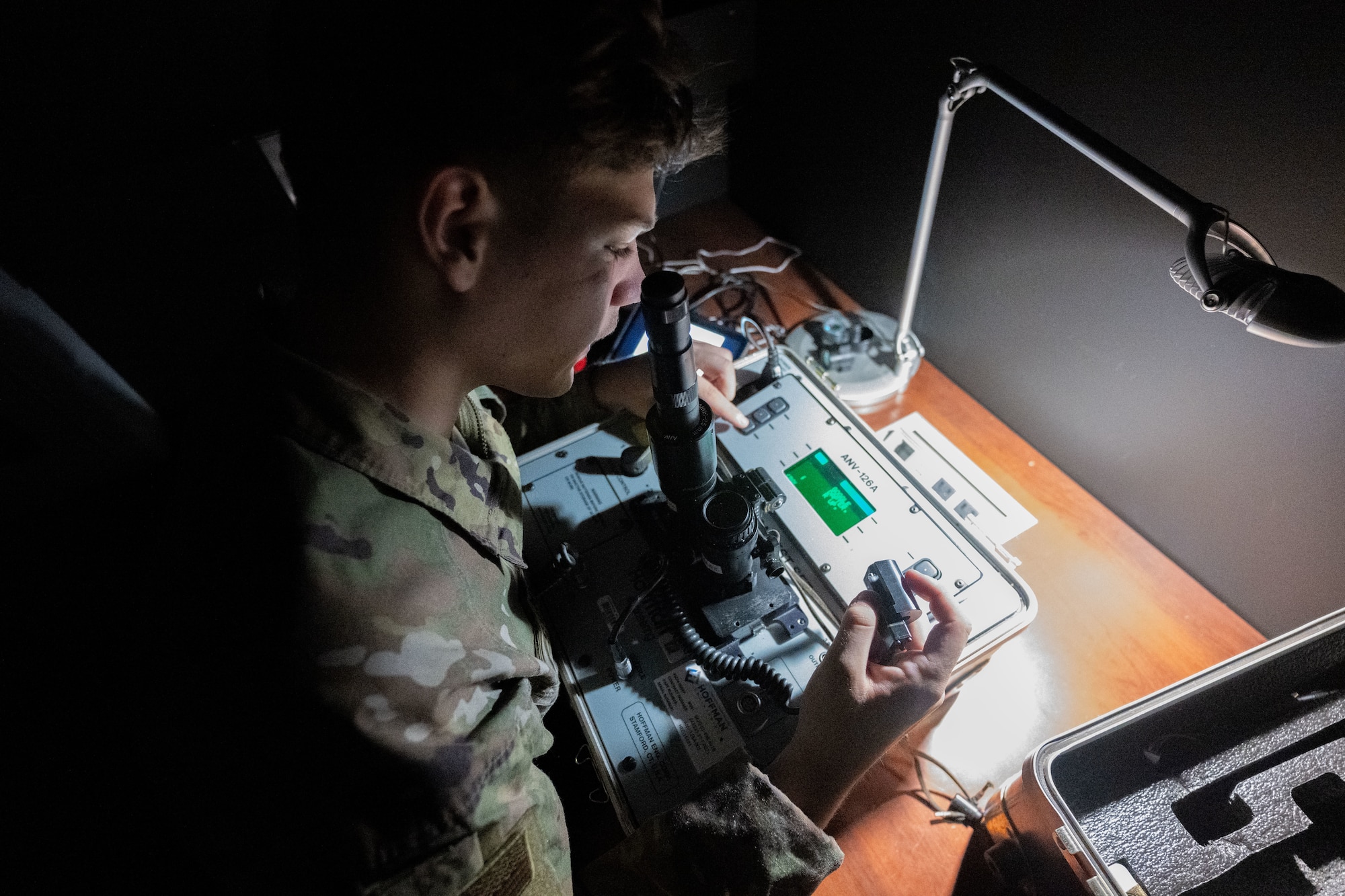 Guy looks into night vision goggles.