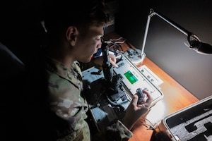 Guy looks into night vision goggles.