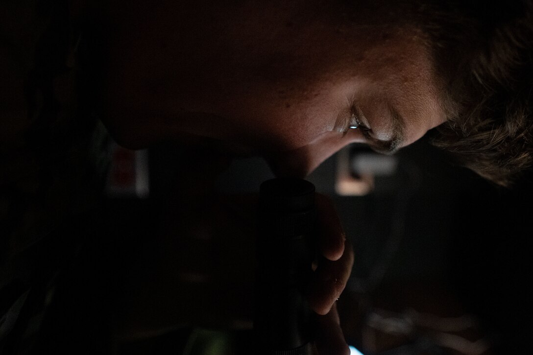 Guy looks into night vision goggles.