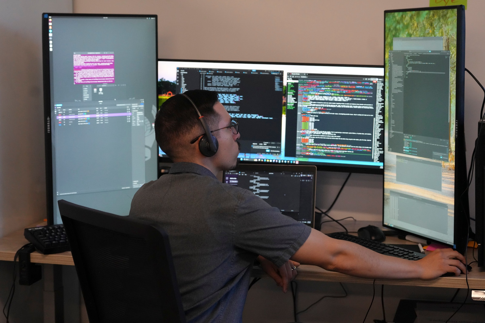 a man wearing a headset works on a computer