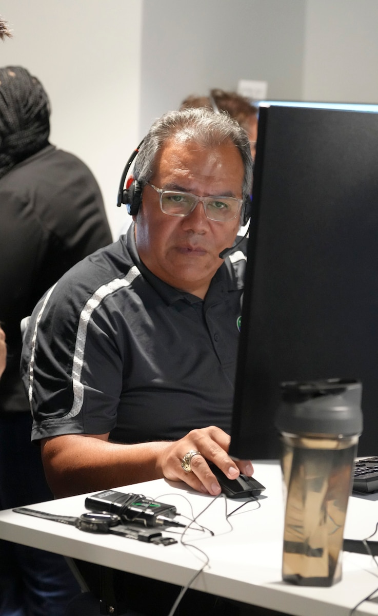 a man wearing a headset works on a computer