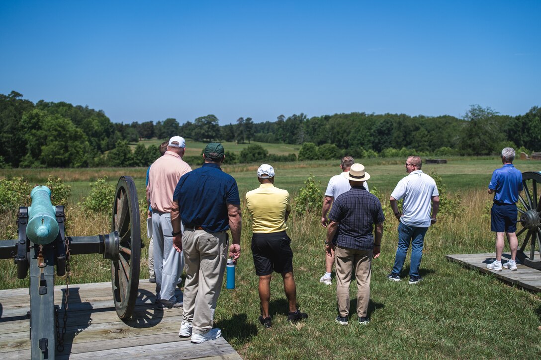 Several people outside look at a sign