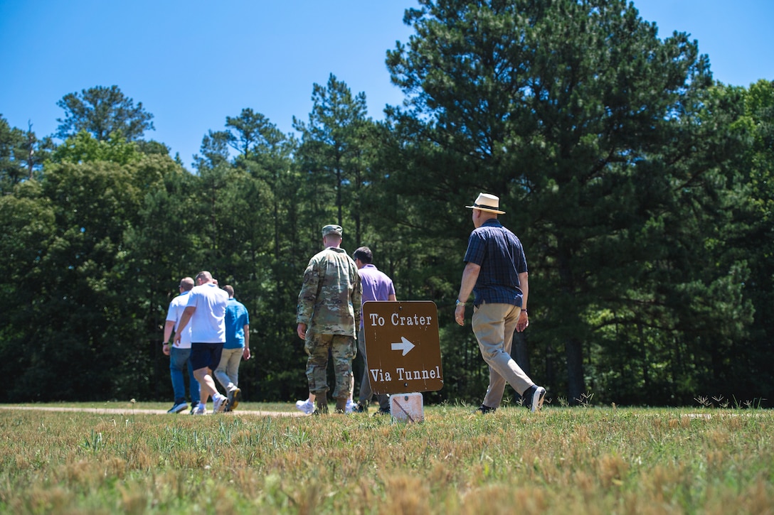 Several people outside look at a sign