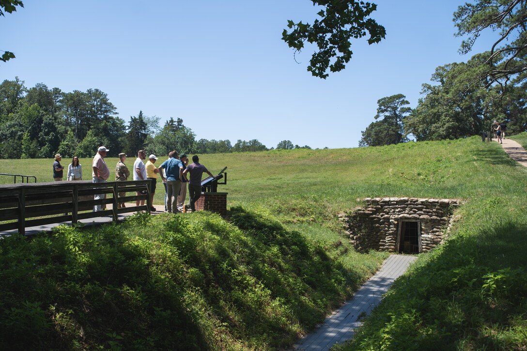 Several people outside look at a sign