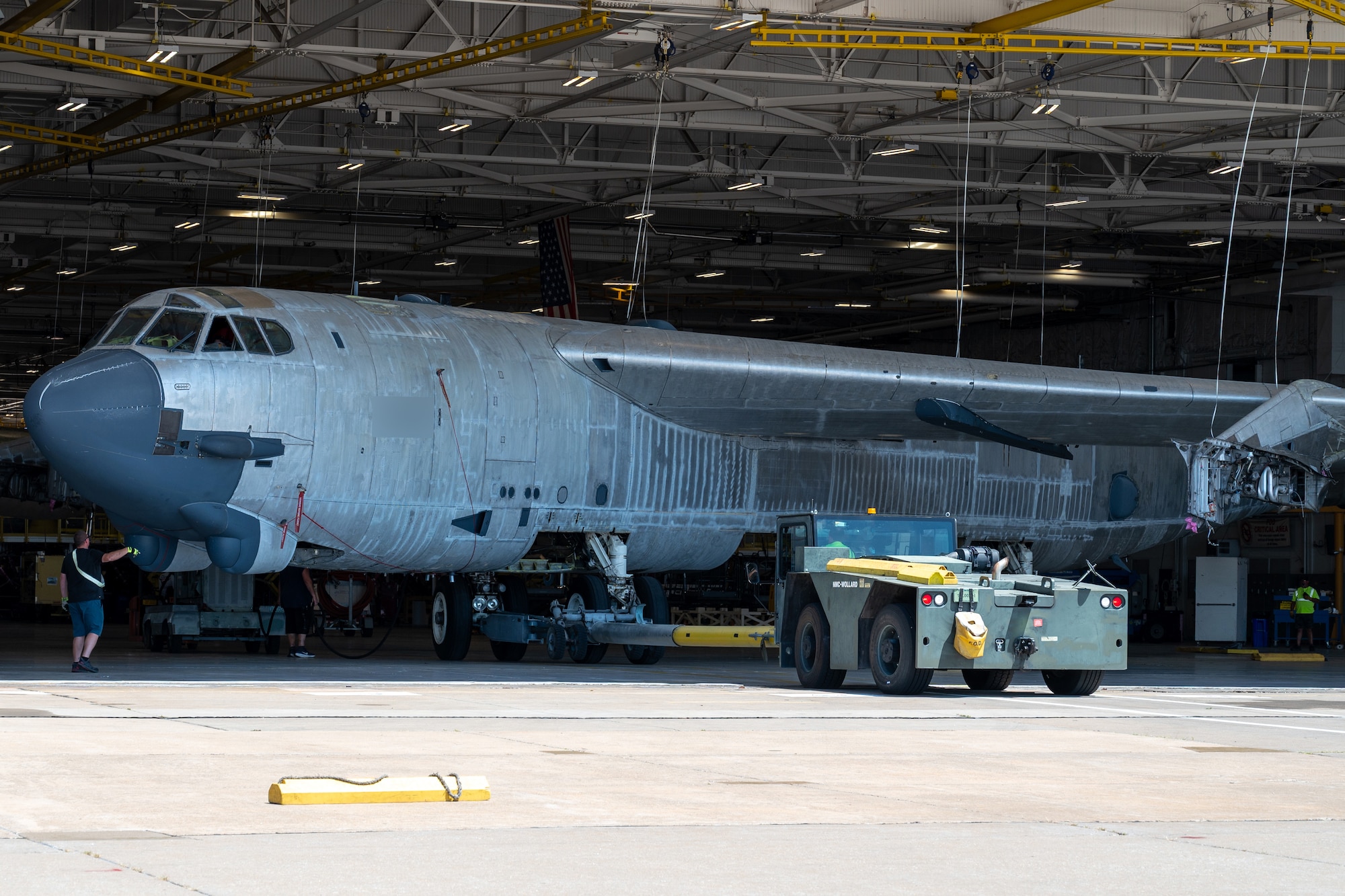 A B-52H Stratofortress undergoing programmed depot maintenance is towed into a hangar at Tinker Air Force Base, Oklahoma, July 28, 2025. The aircraft’s extra-long wingspan is too wide for the hangar, so it “crabs” into the hangar diagonally. Representatives from Boeing were on hand for this towing to study how the Oklahoma City Air Logistics Complex moves the B-52 as the company prepares for Commercial Engine Replacement Program upgrades. (U.S. Air Force photo by Courtney Landsberger)