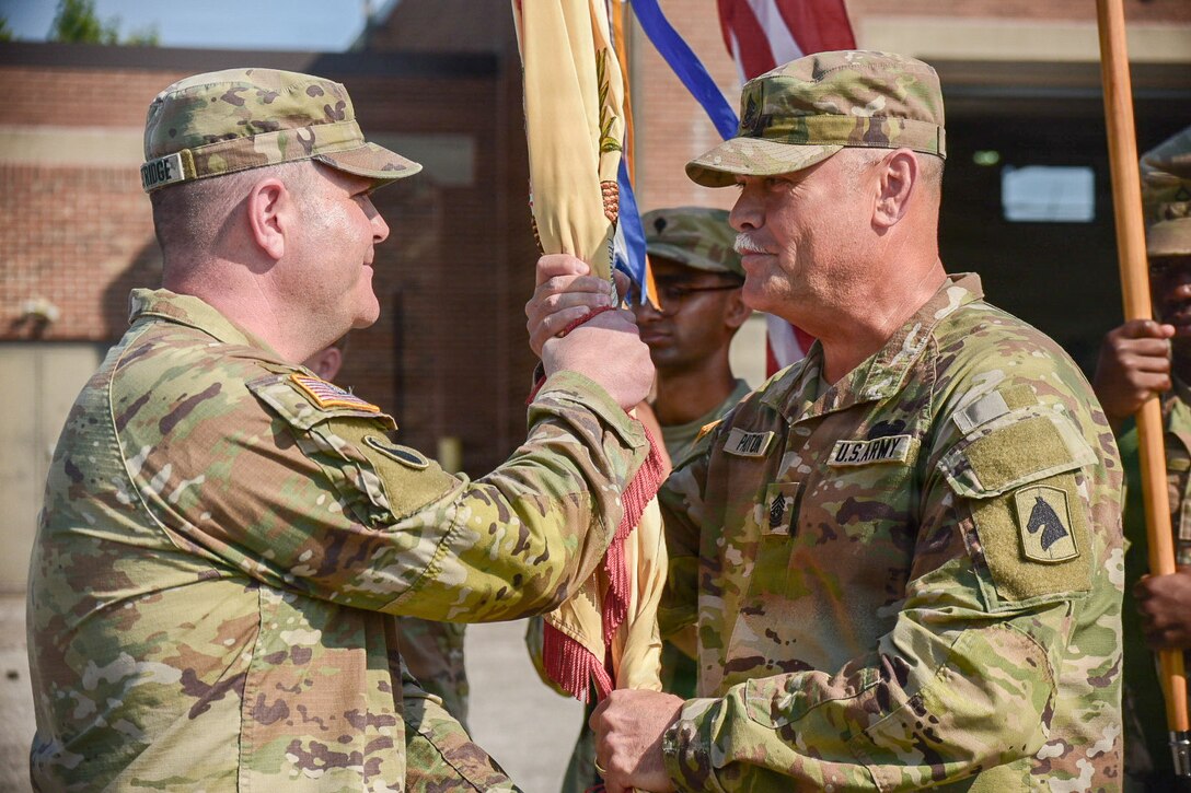 U.S. Army Lt. Col. Eric Eastridge, incoming commander of the 103rd Brigade Support Battalion, passes the battalion colors to Command Sgt. Maj. Thomas Payton, the battalion's senior enlisted advisor, during a change of command ceremony at the 103rd BSB armory in Harrodsburg, Kentucky, Aug. 9, 2026.