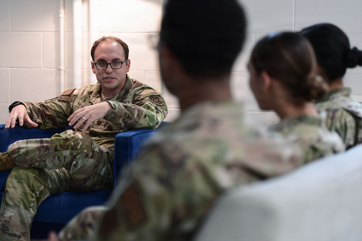 A man in a U.S. Air Force uniform speaks to fellow Airmen.