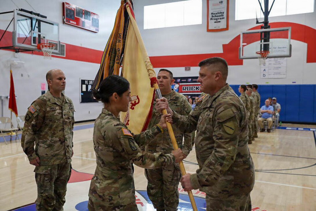 U.S. Army Lt. Col. Jennifer Watson, outgoing commander of the 1792nd Combat Sustainment Support Battalion, recieves the battalion colors from Command Sgt. Maj. Jason Maszor, battalion command sergeant major, during a change of command ceremony at Jody Richards Elementary School in Bowling Green, Kentucky, Aug. 23, 2026.