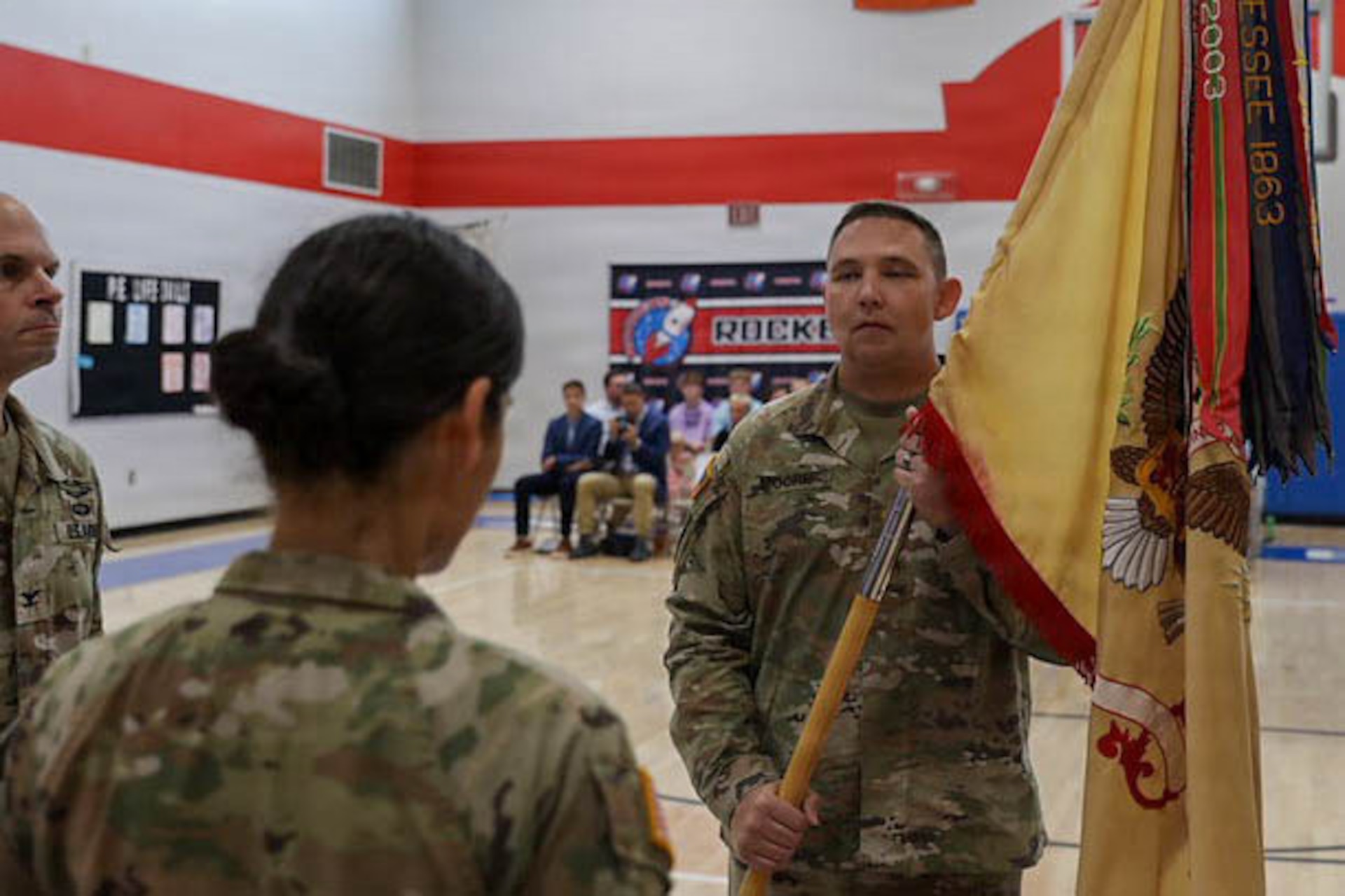 U.S. Army Maj. Anthony Moore, right, incoming commander of the 1792nd Combat Sustainment Support Battalion, receives the battalion colors from Col. Steven Engels during a change of command ceremony at Jody Richards Elementary School in Bowling Green, Kentucky, Aug. 23, 2026.