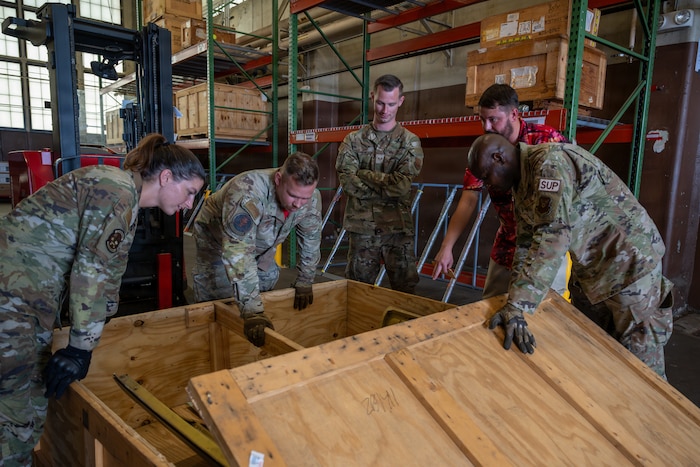 U.S. Airmen from the 96th Bomber Generation Squadron and the 2nd Logistics Squadron unbox a lower wrap cowling part for a B-52H Stratofortress aircraft at Barksdale Air Force Base, Louisiana, July 17, 2026. The 2 LRS routinely supplies aircraft parts, tools, and equipment to the 96th BGS and other maintenance units across the base for repairs on the aircraft. (U.S. Air Force photo by Airman 1st Class Fallon Mitchell)