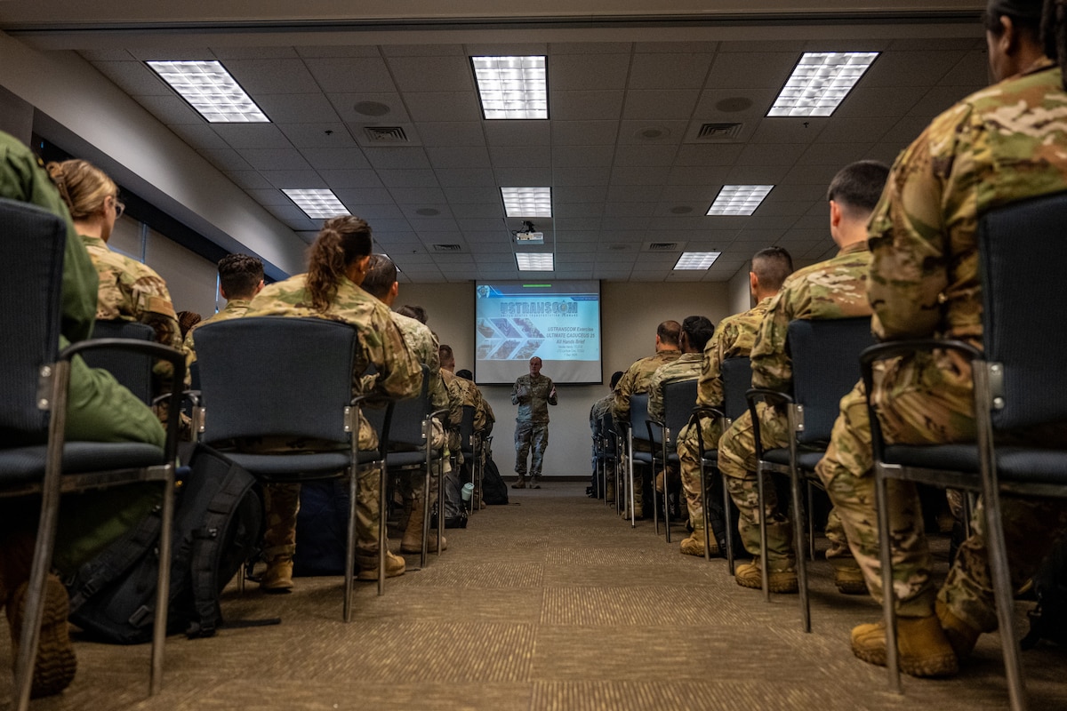 Uniformed service members sit in a classroom facing an instructor who stands at the front of the room and addresses the group during Exercise Ultimate Caduceus 2026.