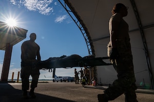 Two Army personnel transport a simulated patient together, demonstrating coordinated movement and interoperability in support of Exercise Ultimate Caduceus 2026 at Scott Air Force Base, Illinois.