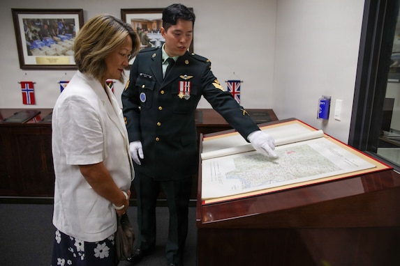Canadian Army Sgt. Buhb Soo Hwang, standing on the right, briefs Ms. Jean Lee, on the left, about the historical background of the Korean War in the Armistice Room at United Nations Command Headquarters on Camp Humphreys, South Korea, on September 4, 2026.