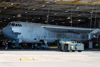 A B-52H Stratofortress undergoing programmed depot maintenance is towed into a hangar at Tinker Air Force Base, Oklahoma, July 28, 2025. The aircraft’s extra-long wingspan is too wide for the hangar, so it “crabs” into the hangar diagonally. Representatives from Boeing were on hand for this towing to study how the Oklahoma City Air Logistics Complex moves the B-52 as the company prepares for Commercial Engine Replacement Program upgrades. (U.S. Air Force photo by Courtney Landsberger)