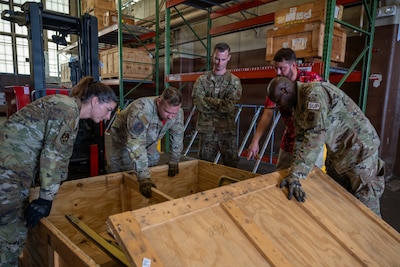 U.S. Airmen from the 96th Bomber Generation Squadron and the 2nd Logistics Squadron unbox a lower wrap cowling part for a B-52H Stratofortress aircraft at Barksdale Air Force Base, Louisiana, July 17, 2026. The 2 LRS routinely supplies aircraft parts, tools, and equipment to the 96th BGS and other maintenance units across the base for repairs on the aircraft. (U.S. Air Force photo by Airman 1st Class Fallon Mitchell)