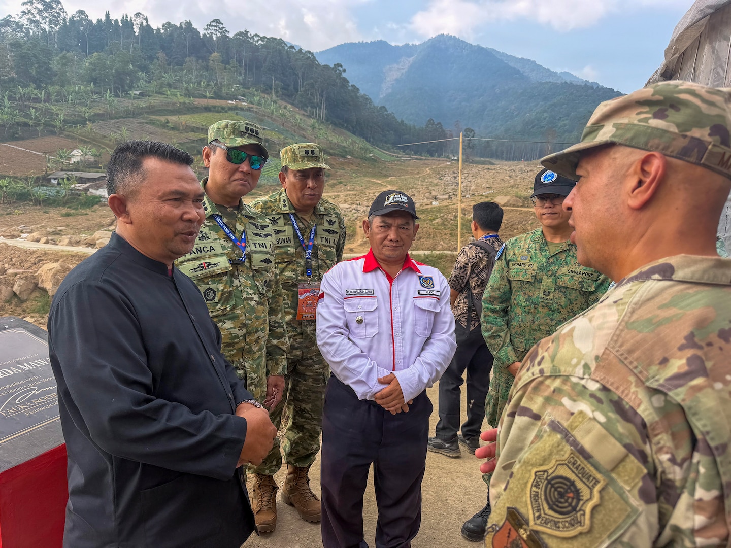 Nur Awaludin Lubis, head official of Pasirlangu Village, and U.S. Air Force Brig. Gen. Phillip L. Mallory, commander of the Hawaii Air National Guard, speak at an area of the village affected by a January 2026 landslide during a humanitarian assistance and disaster relief site survey conducted as part of Super Garuda Shield 2026 near Bandung, Indonesia, Sept. 3, 2026.