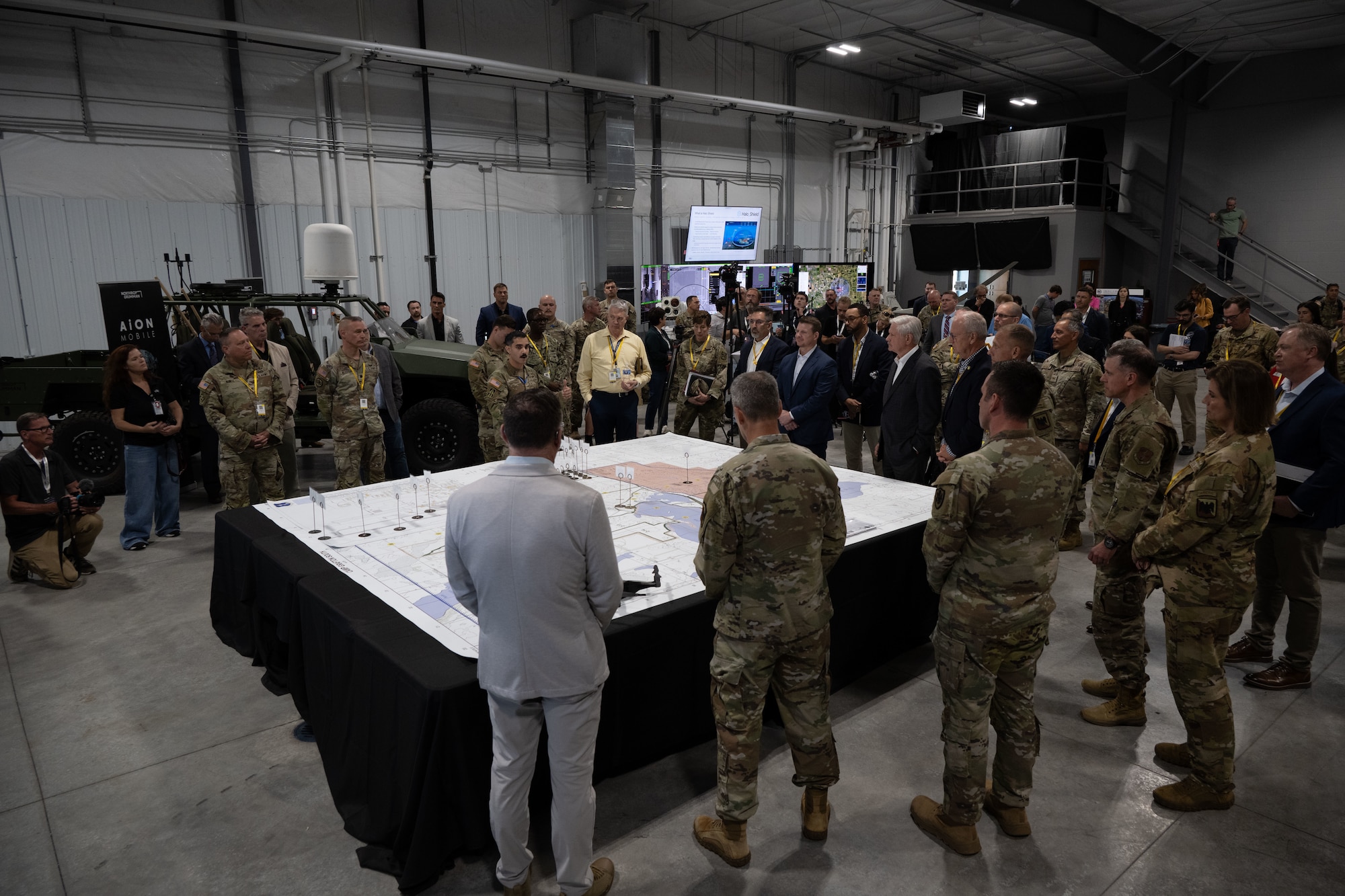 Military leaders, government officials and industry partners gather around a demonstration display during Technology Readiness Experimentation (T-REX) in Grand Forks, North Dakota, Aug. 27, 2026. T-REX provides an operationally relevant environment to evaluate emerging technologies, identify capability gaps and gather feedback from warfighters before systems are fielded. (U.S Air National Guard photo by SSgt. John Macera)