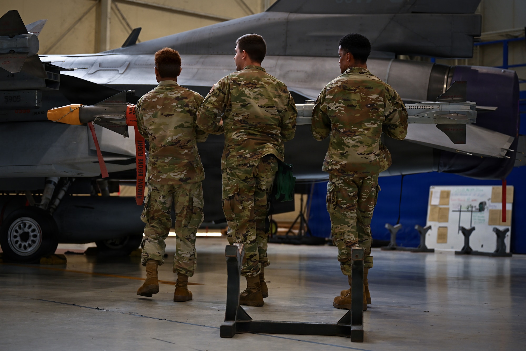 Airmen load a weapons munition.