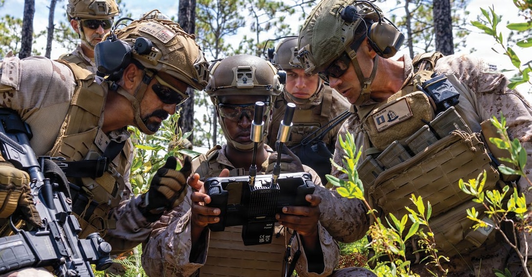 U.S. Marine Corps Sgt. Idris Idris, center, a small unmanned aircraft systems specialist with U.S. Marines with 1st Battalion, 2nd Marine Regiment, 2nd Marine Division, demonstrates the C100 drone capabilities to a Spanish marine during a company live-fire range as a part of Fleet Exercise 250 (FLEETEX) on Marine Corps Base Camp Lejeune, North Carolina, June 19, 2026.