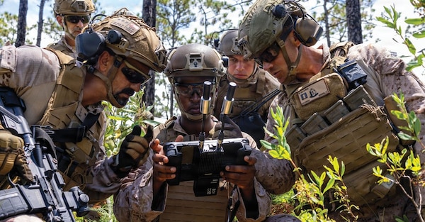 U.S. Marine Corps Sgt. Idris Idris, center, a small unmanned aircraft systems specialist with U.S. Marines with 1st Battalion, 2nd Marine Regiment, 2nd Marine Division, demonstrates the C100 drone capabilities to a Spanish marine during a company live-fire range as a part of Fleet Exercise 250 (FLEETEX) on Marine Corps Base Camp Lejeune, North Carolina, June 19, 2026. FLEETEX 250 represents the United States’ commitment to layer defense of the homeland through forward-deployed forces and reinforces interoperability with allies and partners through collective maritime security. (U.S. Marine Corps photo by Cpl. Channah Chilton)
