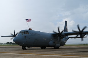 Airmen waives American flag above aircraft