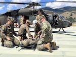 Chief Hospital Corpsman Noah Morrison, right, assists U.S. and allied service members during air medical evacuation familiarization training at the Marine Corps Mountain Warfare Training Center in Bridgeport, California, July 15, 2026. The training provided participants hands-on experience with helicopter casualty loading and hoisting procedures in a high-altitude environment. (Courtesy photo).