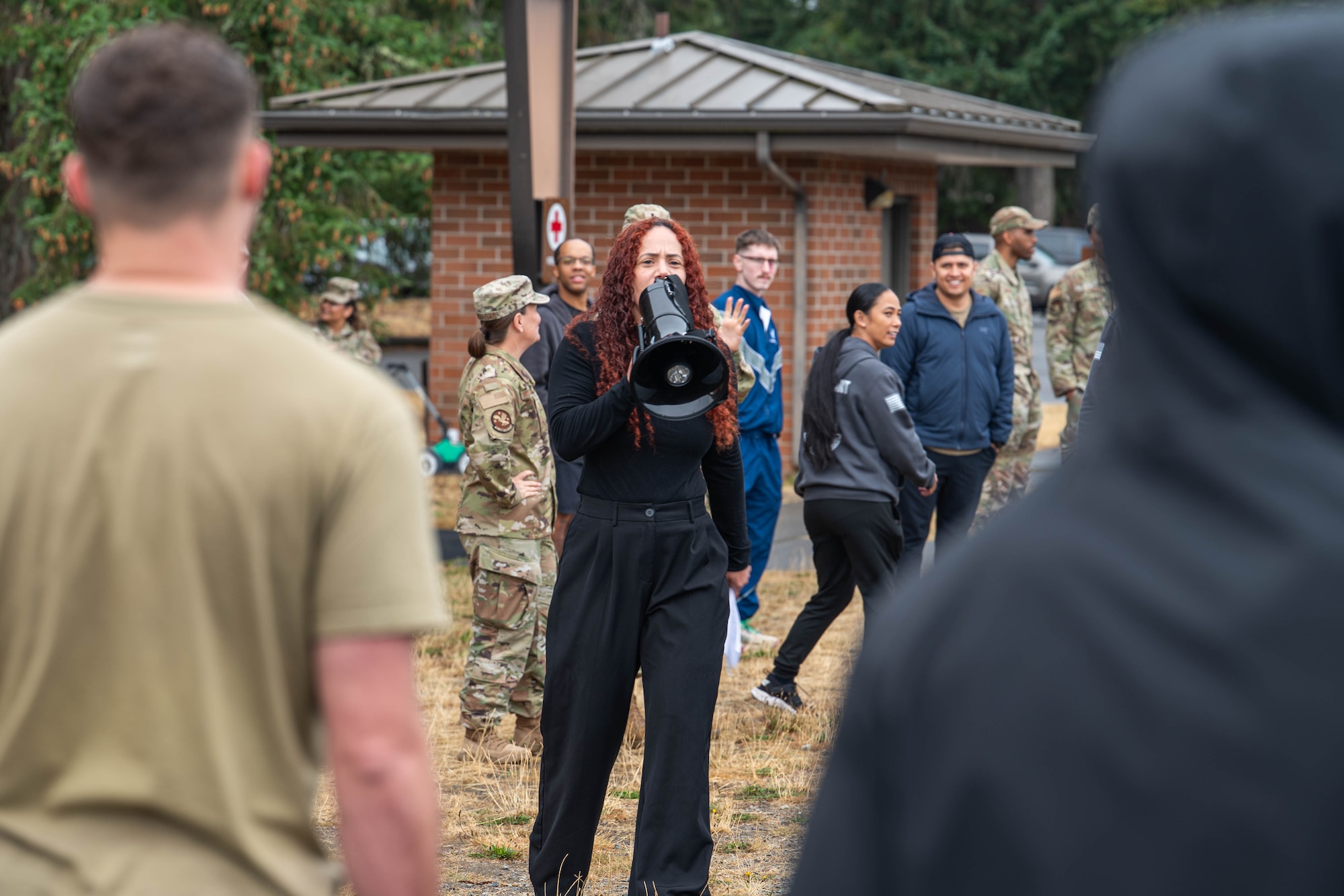 A woman speaks to a group of people through a megaphone.