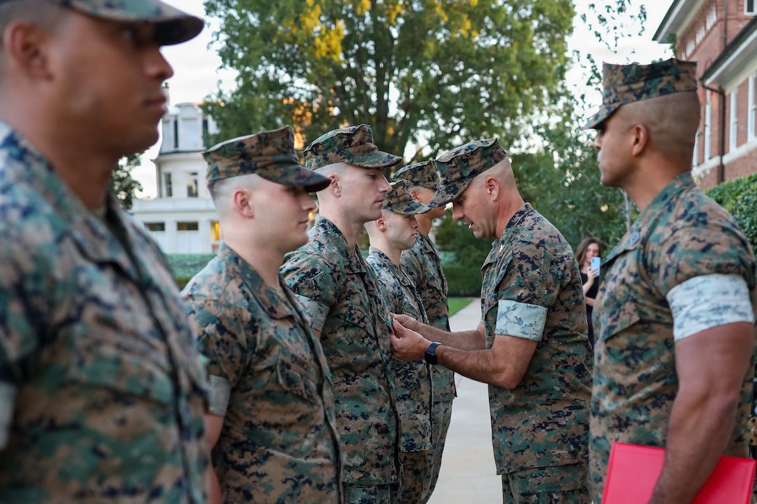 U.S. Marine Corps Col. Jason Copeland, commanding officer, Marine Barracks Washington, presents a Navy and Marine Corps Achievement Medal to Cpl. James McGhee, a White House sentry assigned to Guard Company, Marine Barracks Washington, during an awards ceremony at Marine Barracks Washington, D.C., Sept 9, 2026. Five White House sentries assigned to Guard Company, Marine Barracks Washington, received Navy and Marine Corps Achievement Medals for their professionalism, vigilance and resilience while serving as White House sentries during Operation Midnight Hammer and Operation Absolute Resolve from June 2025 to March 2026. Whether safeguarding the “Oldest Post of the Corps” or standing watch in direct support of the President, Barracks Marines demonstrate the discipline and resilience required to respond when and where they are needed. (U.S. Marine Corps photo by Capt. Lauri Schleicher)