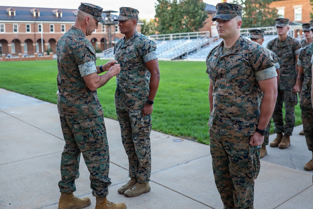 U.S. Marine Corps Col. Jason Copeland, commanding officer, Marine Barracks Washington, presents a Navy and Marine Corps Achievement Medal to Cpl. Jaryn CarrilloTalmadge, a White House sentry assigned to Guard Company, Marine Barracks Washington, during an awards ceremony at Marine Barracks Washington, D.C., Sept 9, 2026. Five White House sentries assigned to Guard Company, Marine Barracks Washington, received Navy and Marine Corps Achievement Medals for their professionalism, vigilance and resilience while serving as White House sentries during Operation Midnight Hammer and Operation Absolute Resolve from June 2025 to March 2026. Whether safeguarding the “Oldest Post of the Corps” or standing watch in direct support of the President, Barracks Marines demonstrate the discipline and resilience required to respond when and where they are needed. (U.S. Marine Corps photo by Capt. Lauri Schleicher)