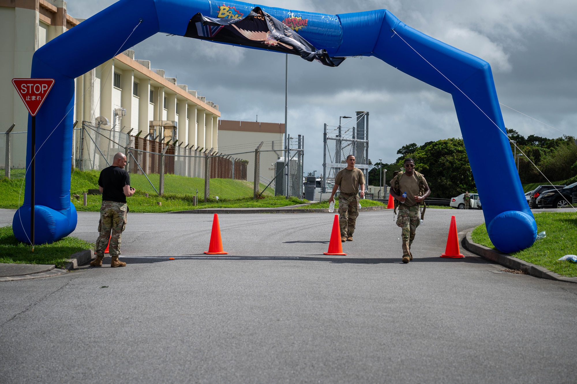 U.S. service members ruck through the finish line of the Royal Danish Air Force Flyver March at Kadena Air Base, Japan, Aug. 29, 2026. Participants are required to carry a ruck weighing at least 23 pounds throughout the 20-kilometer march. (U.S. Air Force photo by Airman 1st Class Nathaniel Jackson)