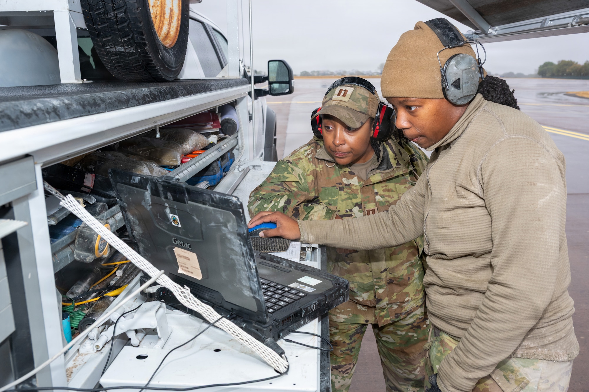 U.S. Air Force Capt. Andi Brown, Air Force Civil Engineer Center Airfield Pavement Evaluation Team officer, left, and Tech. Sgt. Sarah-Ann Wright, NCOIC of coring operations, review data during a comprehensive airfield pavement assessment at RAF Fairford, England, September 2nd 2026. The assessment helps determine what aircraft loads the airfield can safely support and provides data used to plan future maintenance. (U.S. Air Force photo by Senior Airman Adam Enbal)