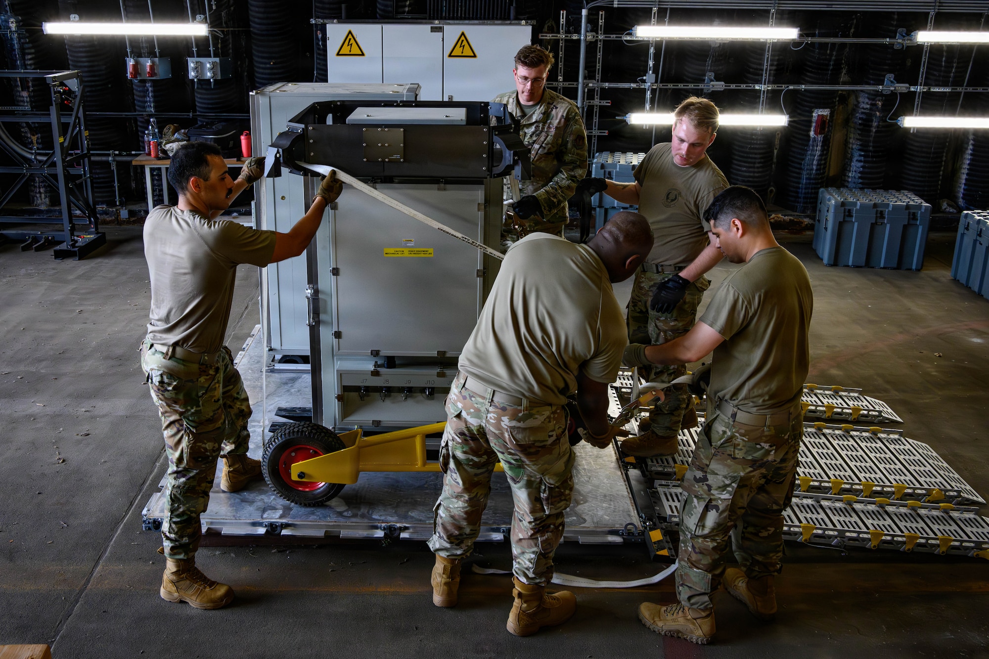 U.S. Air Force Airmen move equipment off a pallet.