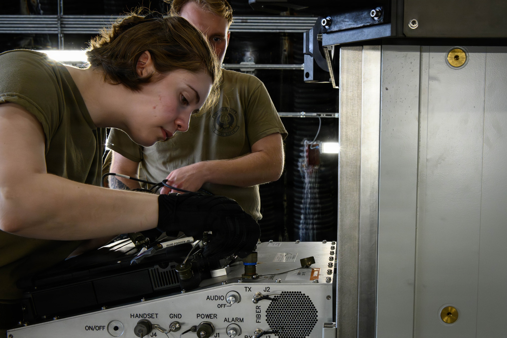 A U.S. Air Force Airman hooks up cables to a computer.