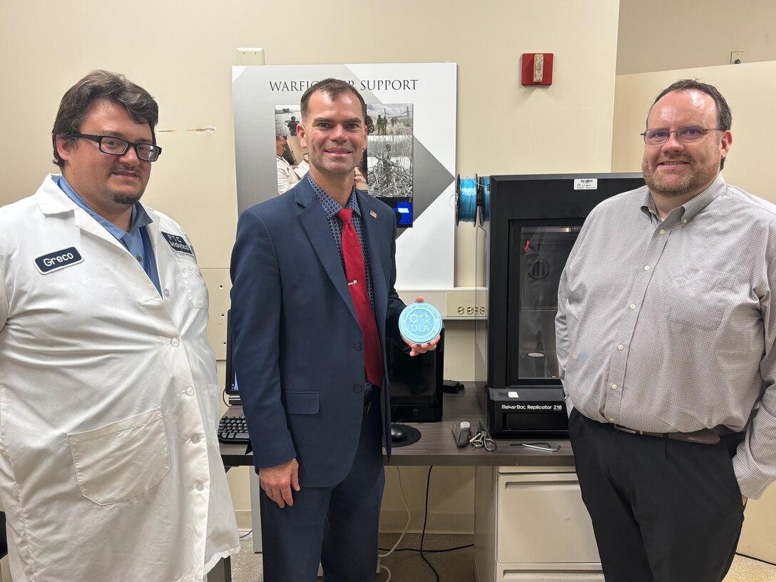 Research and Development Senior Logistics Analyst Jonathan Adkins shows a printed coaster as he stands with Product Test Center Analytics engineer Lawrence Greco and PTC Analytical Lab Manager Mike McClain in Philadelphia.