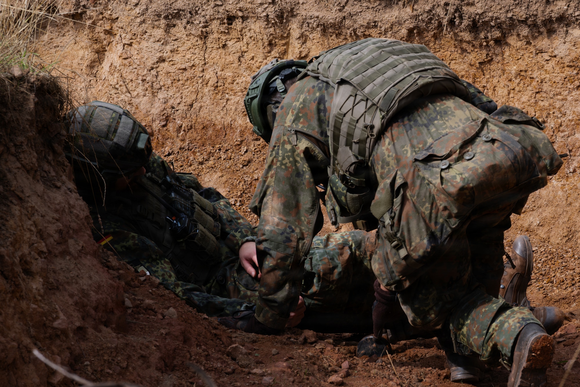 Two men crouched in a trench.
