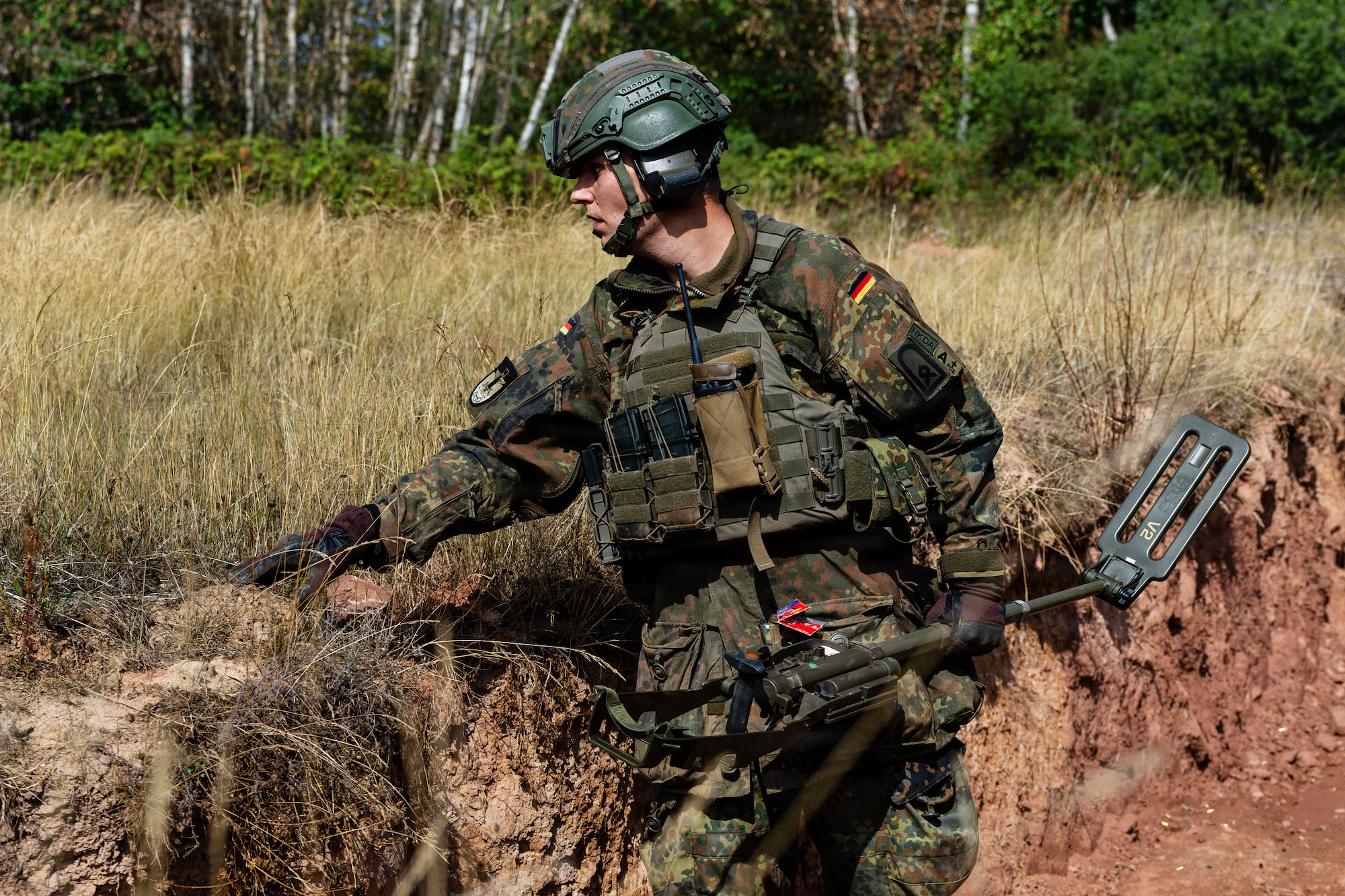 A man stands in a trench.