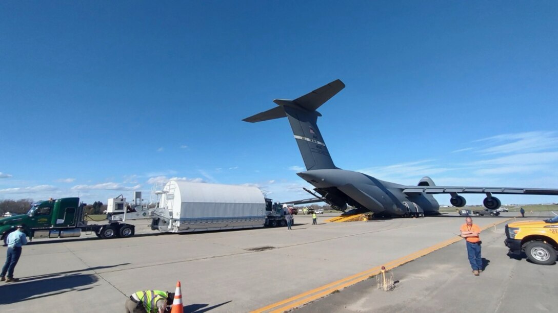 Cargo is uploaded to a military aircraft on the flightline