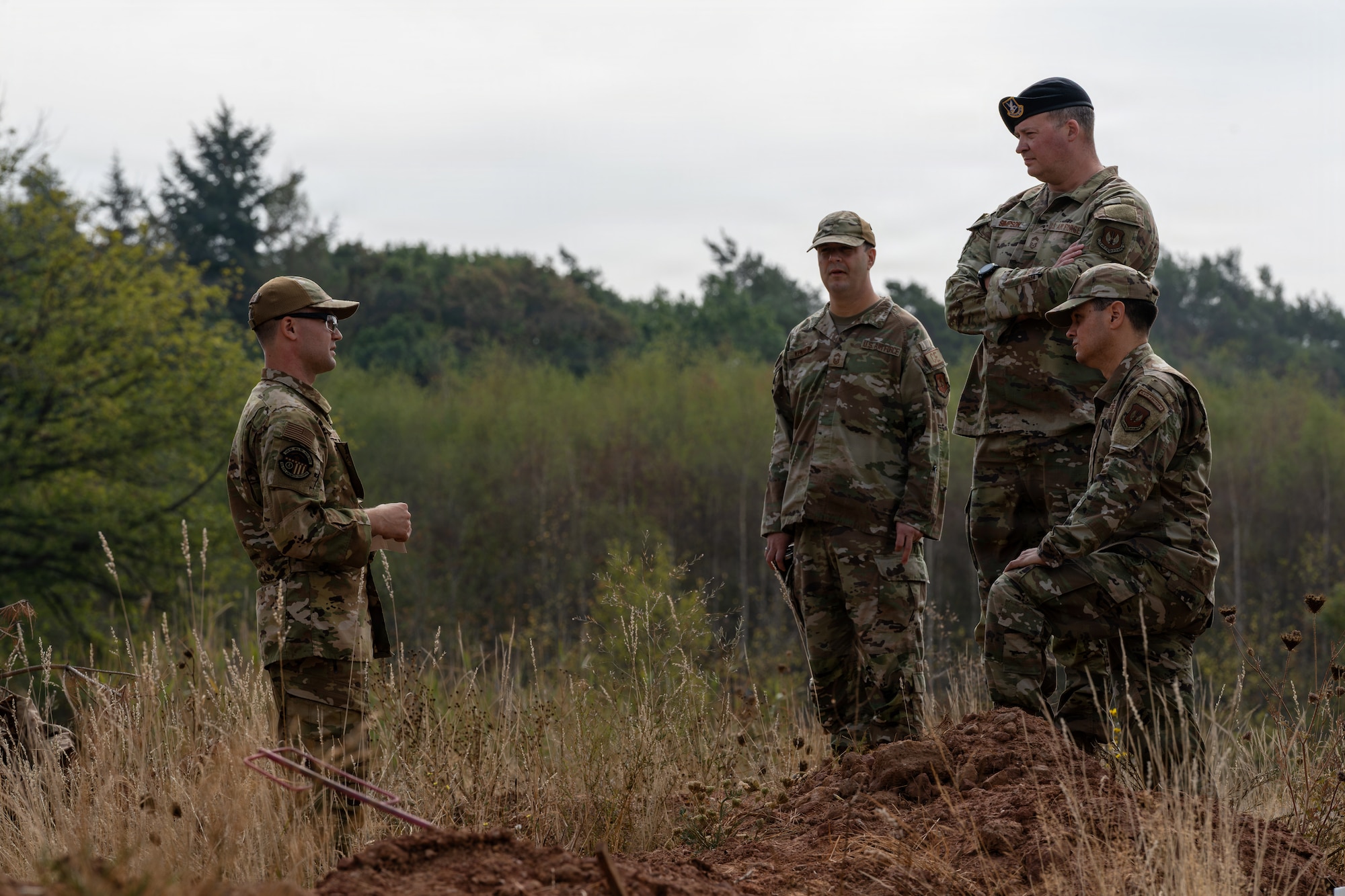 U.S. Air Force Airmen stand in a field.