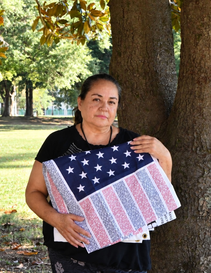 Sandra Nunez-Lopez, a medical support assistant at Kenner Army Health Clinic, holds a folded Flag of Honor close to her heart.